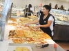 A staff member prepares hot pizza at the Grande Cheese grand opening.