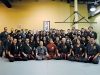 Hokama and Shiroma sit surrounded by Northern Karate instructors and students, posing for a picture commemorating their visit. 