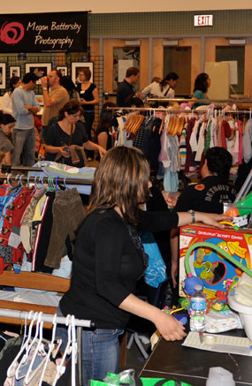 Mothers and fathers peruse the mountain of baby clothing, toys and accessories available at the Mom 2 Mom Sale.